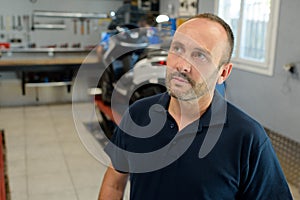 contemplative motorcycle mechanic in garage