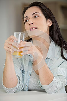 contemplative woman holding glass juice