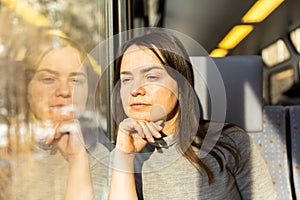 Contemplative woman looking out window while travelling by train
