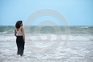 Contemplative woman seen standing in ocean