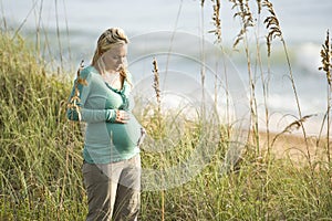 Contemplative young pregnant woman at beach