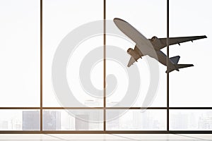 Contemporary airport interior with flying airplane seen through panoramic window with city view and daylight. Take off, travel and