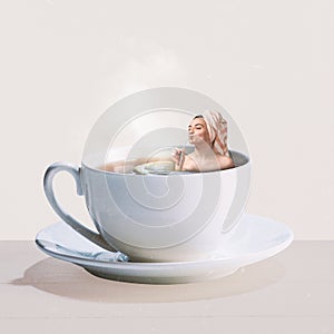 Contemporary art collage. Creative design. Young girl lyuing into hot black tea cup. Relaxation. Taking steam bath