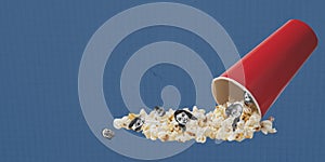Contemporary art collage. Surreal design with popcorn basket spilling over and human face elements. Movie time