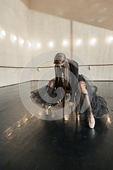 Contemporary ballet dancer on a wooden chair on a repetition