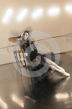 Contemporary ballet dancer on a wooden chair on a repetition