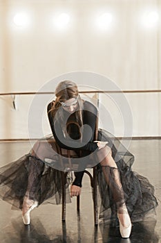 Contemporary ballet dancer on a wooden chair on a repetition