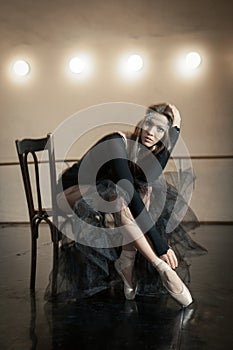 Contemporary ballet dancer on a wooden chair on a repetition