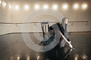 Contemporary ballet dancer on a wooden chair on a repetition