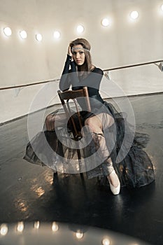 Contemporary ballet dancer on a wooden chair on a repetition