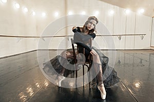 Contemporary ballet dancer on a wooden chair on a repetition