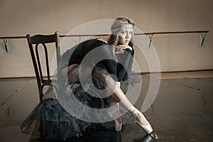 Contemporary ballet dancer on a wooden chair on a repetition