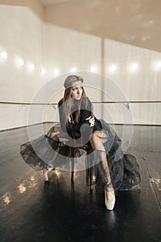 Contemporary ballet dancer on a wooden chair on a repetition