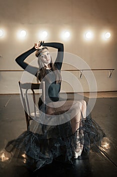 Contemporary ballet dancer on a wooden chair on a repetition