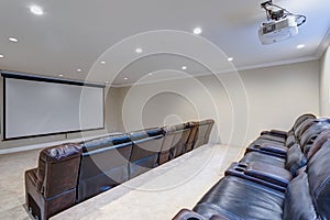 Contemporary basement movie room with black leather chairs