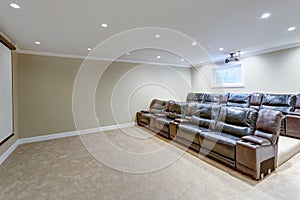 Contemporary basement movie room with black leather chairs