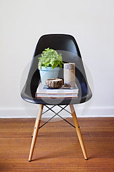 Contemporary black dining chair with plant books and candles