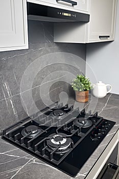 Contemporary black tempered glass gas stove hob with four burners with auto ignition knob cast iron pan supports fan