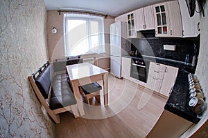 Contemporary black and white kitchen with functional cupboards and modern equipment fisheye photo
