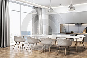 Contemporary bright and concrete kitchen interior with dining area, curtain, window and city view. Luxury designs concept.