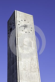 Contemporary clock tower against blue sky