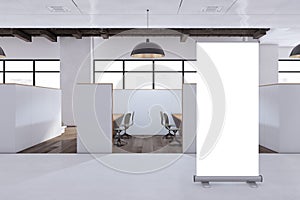Contemporary coworking office interior with empty white roll-up banner and mock up place, partitions and furniture.