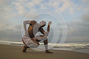 Contemporary dance choreographer and dancer doing ballet beach workout . a young attractive and athletic black African American