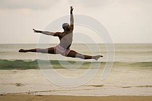Contemporary dance choreographer doing ballet beach workout . young attractive and athletic black African American man dancing on