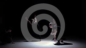 Contemporary dance of four talanted dancers on black, shadow, slow motion