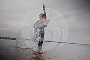 contemporary dancer in black clothes dancing in the sea