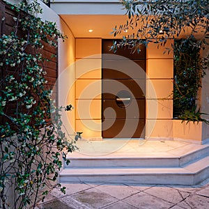 Contemporary design house entrance dark brown door, illuminated
