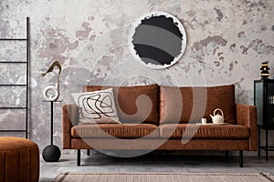 Contemporary design of living room interior with modern brown sofa, mock up poster frame, vase with dried flowers, pouf and