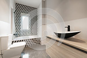 Contemporary designer bathroom with teardrop shaped black porcelain toilets with shower column and black faucets and 3d graphic