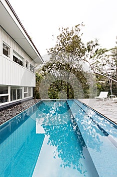 Contemporary fully tiled swimming pool in mid century modern home