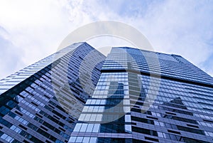 Contemporary glass corporate buildings bottom upwards view, blue toned