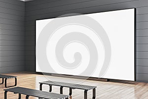 Contemporary gray wooden gallery interior with benches in front of empty white mock up screen.