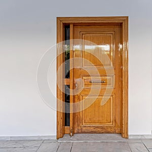 A contemporary house entrance natural solid door on white-washed wall.