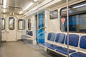 Contemporary inside space of the underground railway carriage with empty seats.