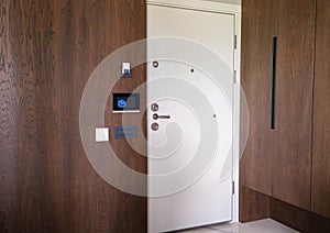 Contemporary interior of entrance hall in luxury apartment. Door with steel door. Door handle on wood oak door panel