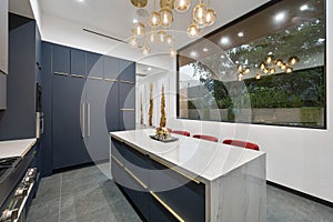 Contemporary kitchen with  blue cabinets and a marble countertop