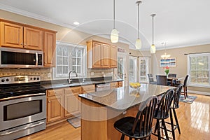 Contemporary kitchen features modern hardwood flooring, glossy granite counter tops