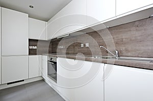 Contemporary kitchen with natural stone worktop and tiles in white