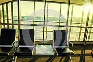 Contemporary lounge with seats in the airport during sun set or