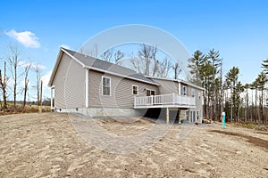 Contemporary and modern ranch-style house in the countryside with a gabled roofline and a balcony