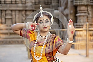 Contemporary Odissi Dancer wears traditional costume posing at Konark sun temple, Odisha, India. Culture and traditions of India.