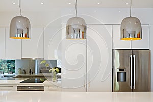 Contemporary pendant lights hanging over kitchen island