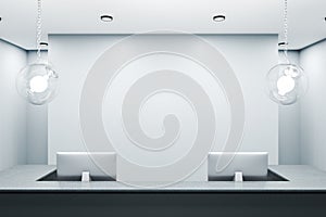 Contemporary reception table with two computers and blank wall