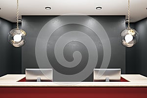 Contemporary red reception table with two computers and blank wall