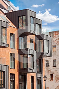 Contemporary Residential Building Exterior in the Daylight with modern balcony and brick facade.