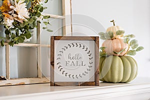 Contemporary stacked pumpkins on the mantel with a sign that say photo